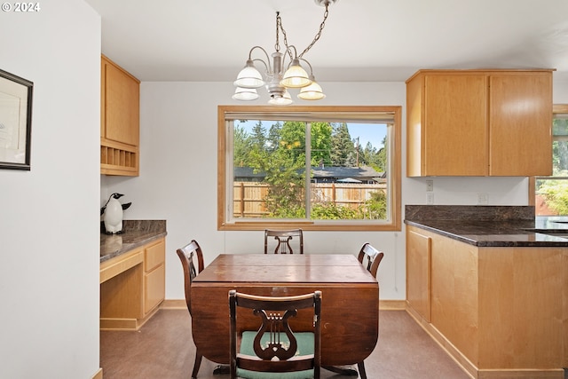 kitchen with hanging light fixtures, dark colored carpet, and an inviting chandelier