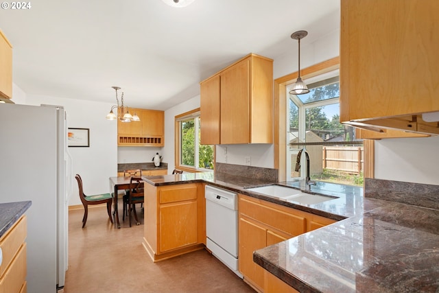 kitchen featuring white appliances, an inviting chandelier, sink, kitchen peninsula, and hanging light fixtures