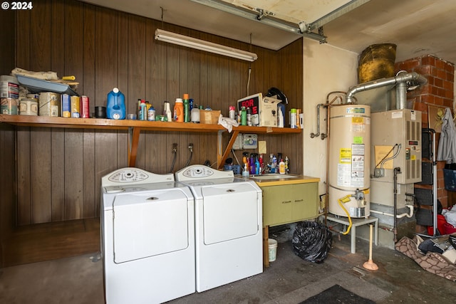 washroom with water heater, independent washer and dryer, and wooden walls