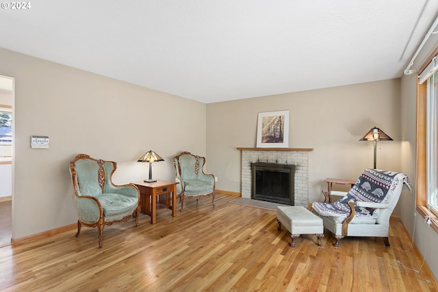 sitting room with a fireplace and light hardwood / wood-style flooring