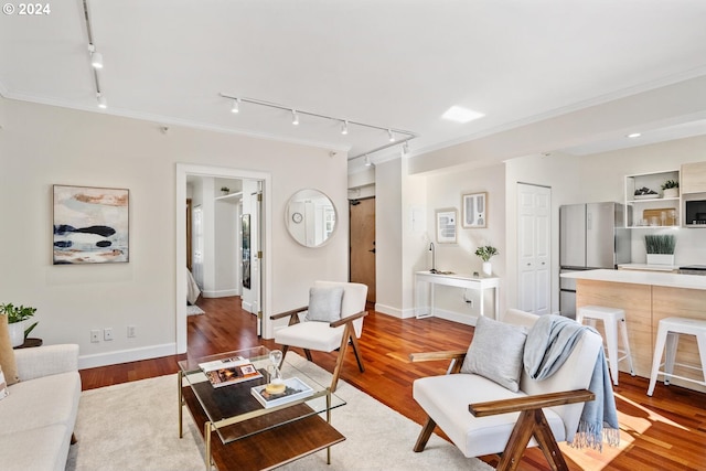 living room featuring ornamental molding, light hardwood / wood-style floors, and rail lighting