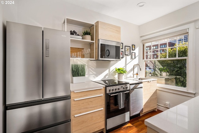 kitchen featuring light brown cabinetry, appliances with stainless steel finishes, dark wood-type flooring, and sink