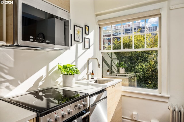 kitchen featuring stainless steel appliances, sink, and radiator heating unit