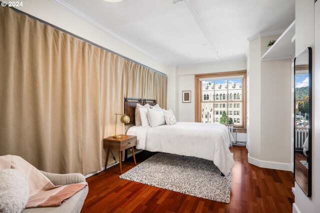 bedroom featuring ornamental molding and dark hardwood / wood-style floors