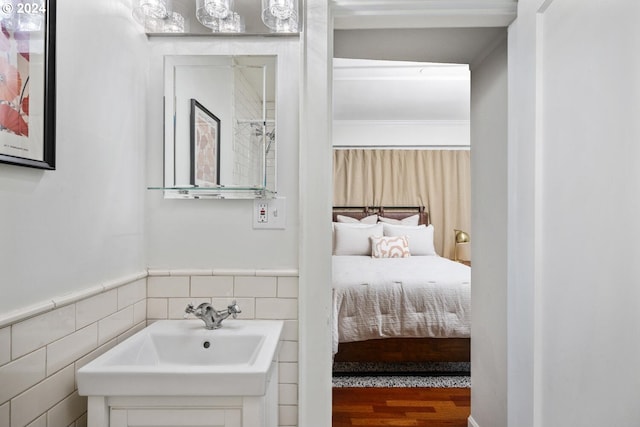 bathroom featuring tile walls, wood-type flooring, and sink