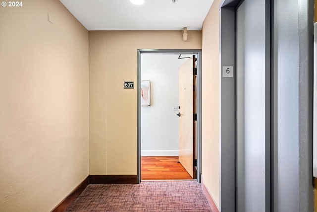 hallway with hardwood / wood-style flooring