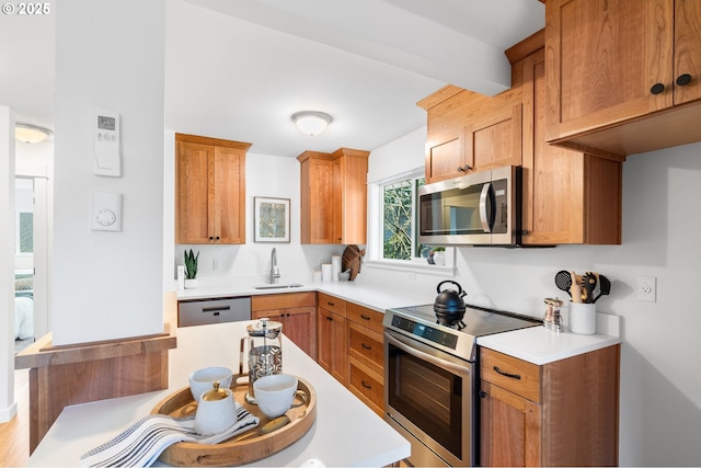 kitchen featuring beam ceiling, sink, and stainless steel appliances