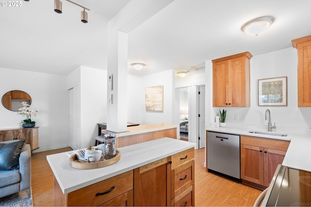 kitchen with dishwasher, a center island, light hardwood / wood-style flooring, and sink