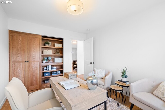 home office featuring light hardwood / wood-style floors and built in features