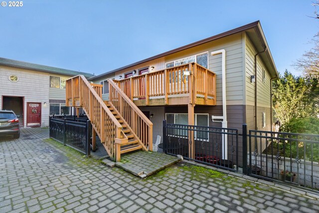 rear view of house featuring a wooden deck