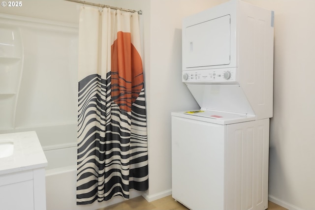 clothes washing area featuring stacked washer and clothes dryer