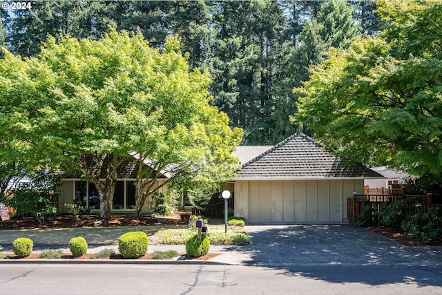 view of front of house with aphalt driveway and fence