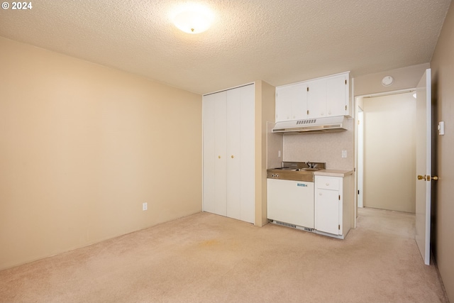 kitchen featuring under cabinet range hood, white cabinets, light carpet, and stove