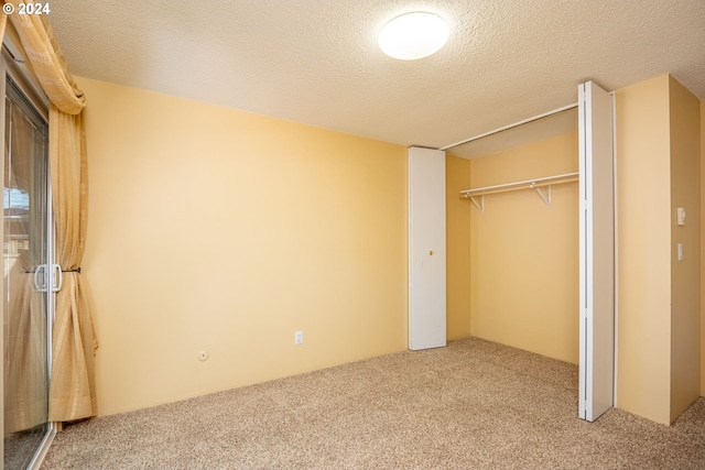 unfurnished bedroom featuring a closet, carpet, and a textured ceiling