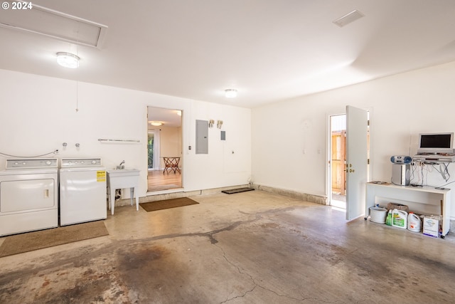 garage featuring electric panel, a sink, and washing machine and clothes dryer