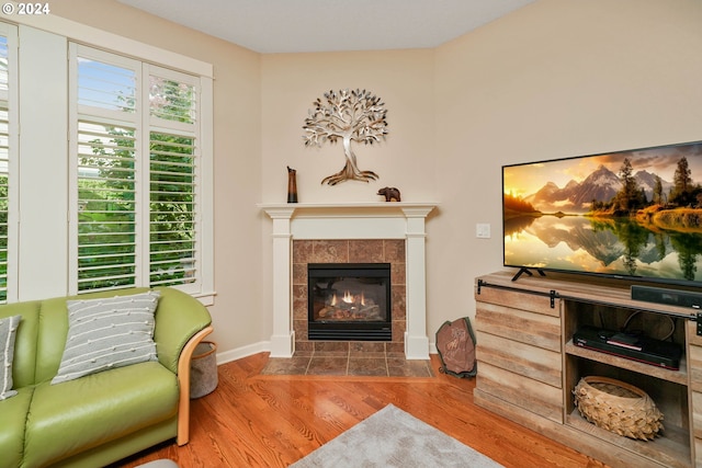 living area featuring hardwood / wood-style flooring and a tile fireplace