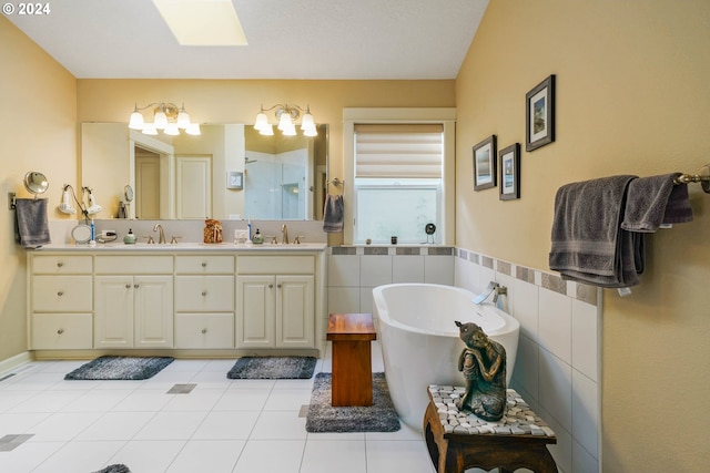 bathroom featuring tile patterned flooring, tile walls, a skylight, vanity, and plus walk in shower