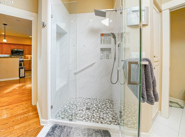 bathroom featuring a shower with door and hardwood / wood-style floors