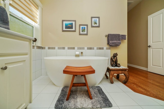 bathroom featuring a bathing tub, tile walls, and tile patterned floors