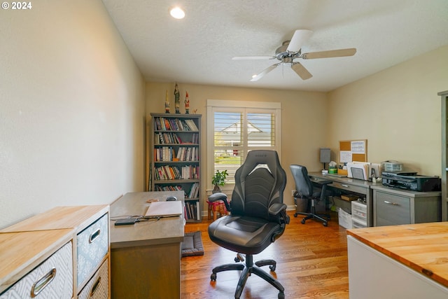 home office with ceiling fan, a textured ceiling, and light wood-type flooring