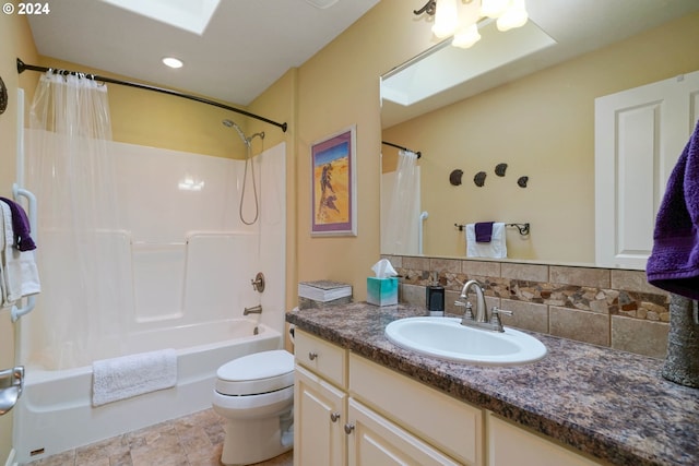 full bathroom featuring a skylight, shower / bath combination with curtain, decorative backsplash, vanity, and toilet