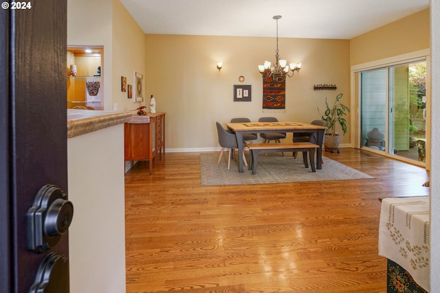 dining space featuring light hardwood / wood-style floors and a notable chandelier