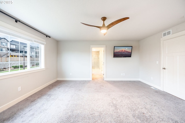 empty room with light colored carpet and ceiling fan