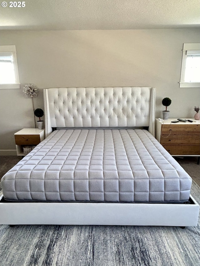 bedroom featuring a textured ceiling and multiple windows