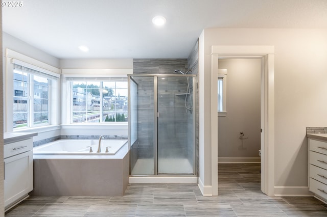 full bathroom featuring separate shower and tub, vanity, and toilet