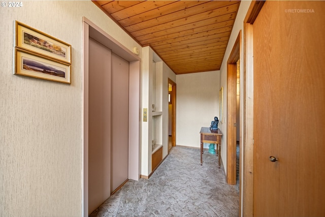 hallway with elevator, light carpet, and wood ceiling