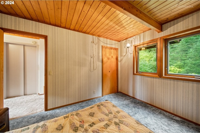 spare room with carpet flooring, wood ceiling, and beam ceiling