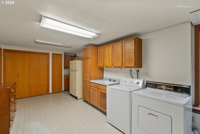 washroom with cabinets, separate washer and dryer, a textured ceiling, and sink