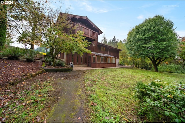 back of property featuring a lawn and a sunroom