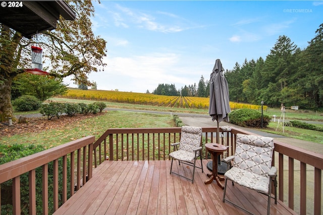 deck featuring a rural view and a lawn