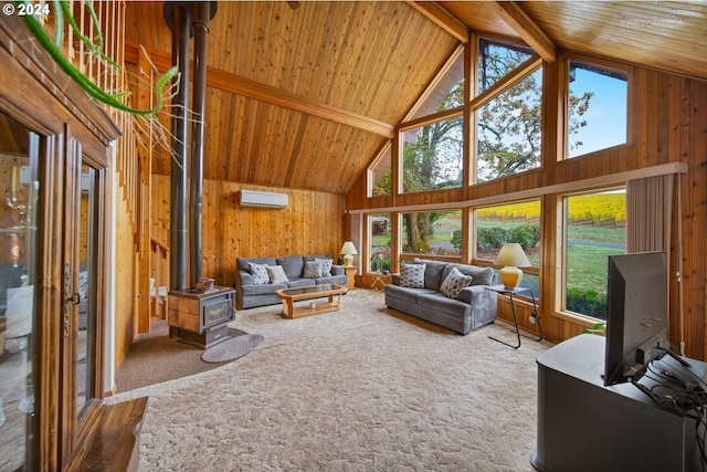 carpeted living room featuring a wall unit AC, plenty of natural light, wood walls, and beam ceiling