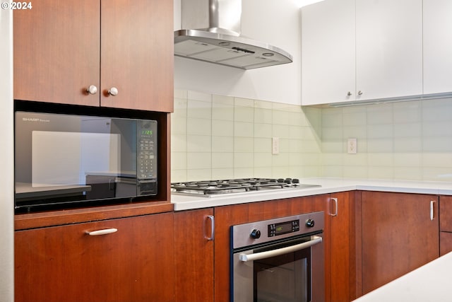 kitchen with decorative backsplash, white cabinetry, appliances with stainless steel finishes, and ventilation hood