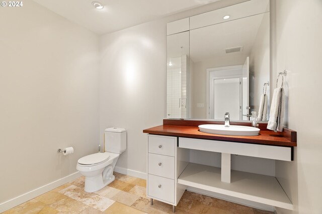 bathroom with tile patterned flooring, toilet, and vanity