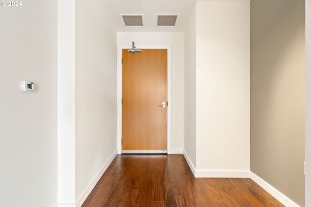 corridor with hardwood / wood-style flooring