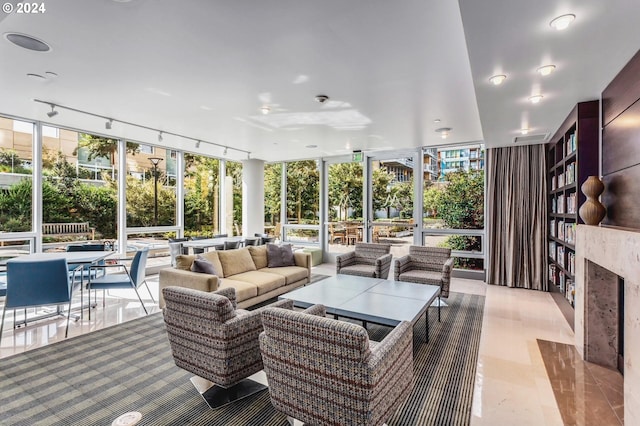 sunroom with a fireplace and track lighting