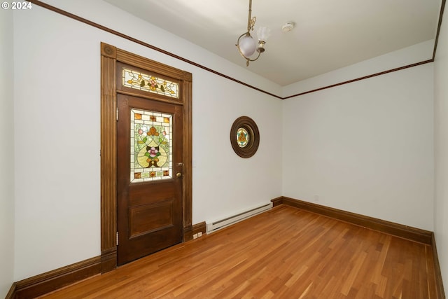 entrance foyer with baseboard heating and hardwood / wood-style floors