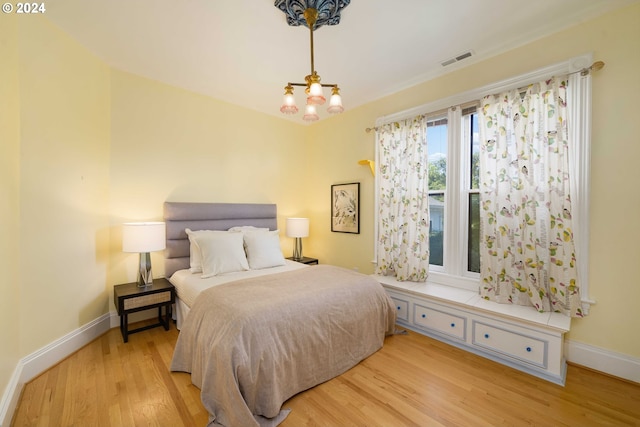 bedroom with a chandelier and light hardwood / wood-style floors