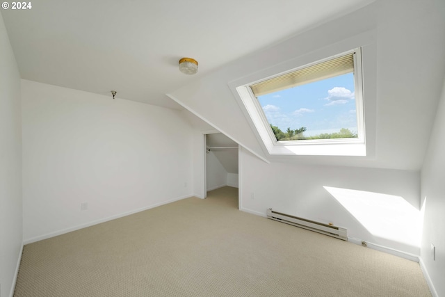 additional living space with vaulted ceiling, light carpet, and a baseboard heating unit