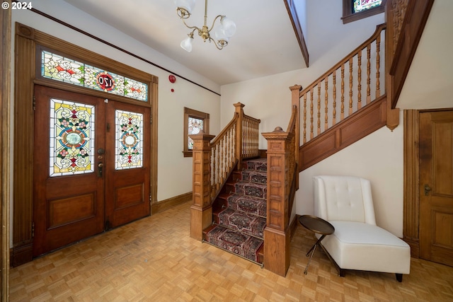 foyer entrance with a chandelier, french doors, and light parquet floors