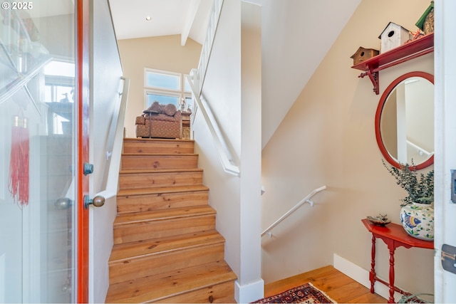 staircase featuring lofted ceiling and hardwood / wood-style floors