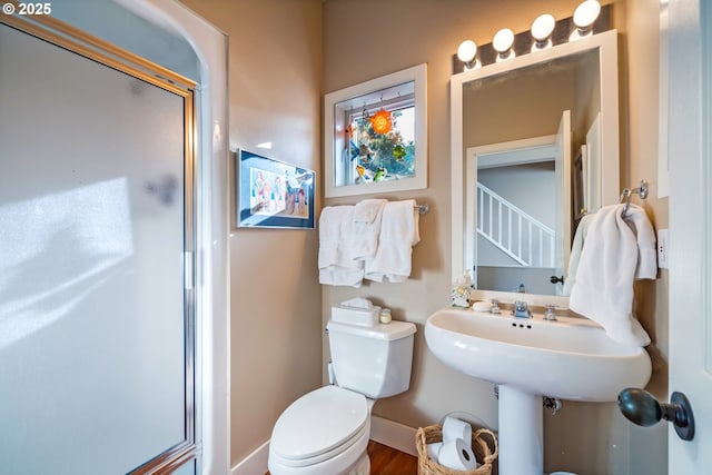 bathroom featuring hardwood / wood-style flooring, toilet, and an enclosed shower