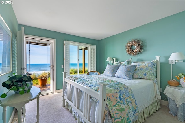 carpeted bedroom featuring a water view and access to exterior