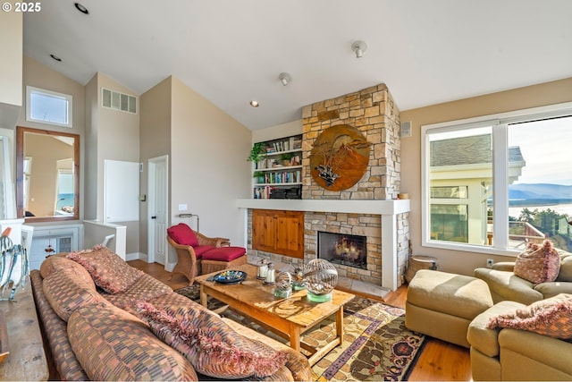 living room with light hardwood / wood-style flooring, vaulted ceiling, and plenty of natural light