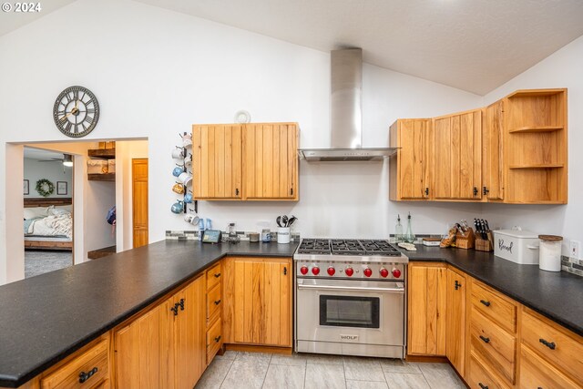 kitchen with vaulted ceiling, wall chimney exhaust hood, and premium stove