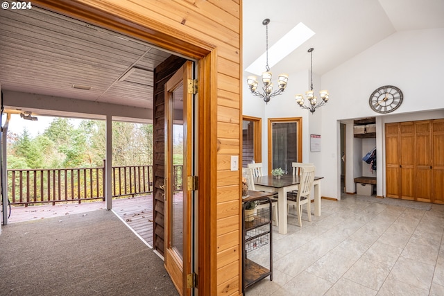 interior space with light carpet, lofted ceiling with skylight, wooden ceiling, and a notable chandelier