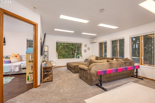 living room with a healthy amount of sunlight, carpet floors, and a wall unit AC